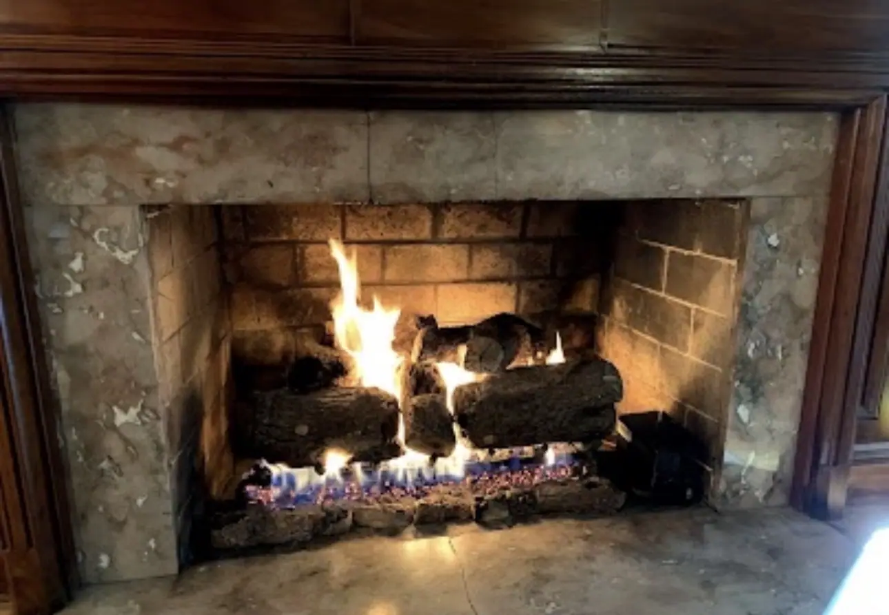 Original PüR-AyR gas fireplace job photograph with lit logs
